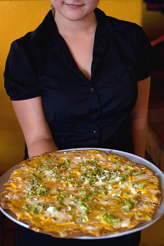 Waitress serving a cheese crisp at El Charro