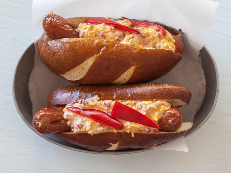 Pimento Cheese Hot Dog with Red Peppers on a Pretzel Bun