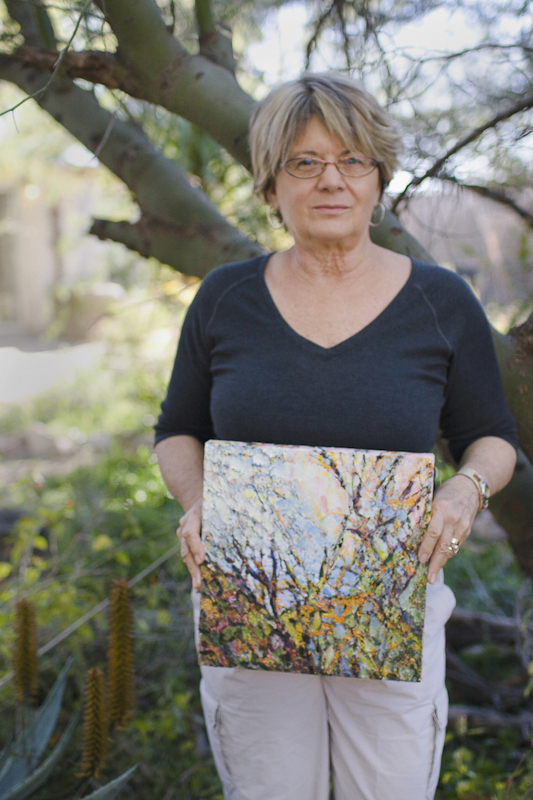 Acadia Alder in her garden holding a painting