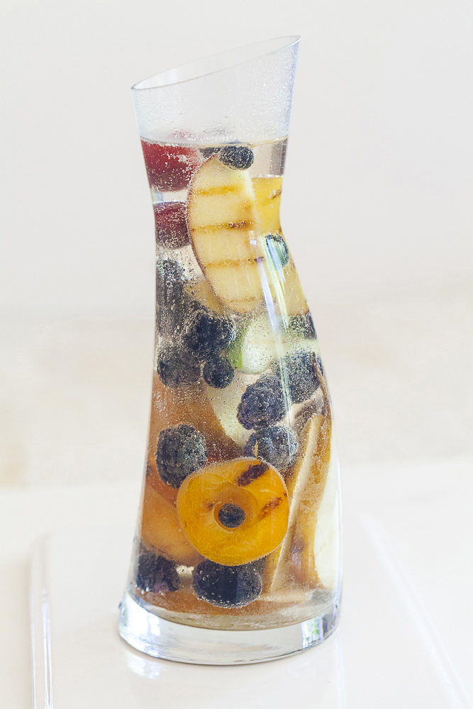 carafe of non-alcoholic sangria with berries and grilled stone fruit 