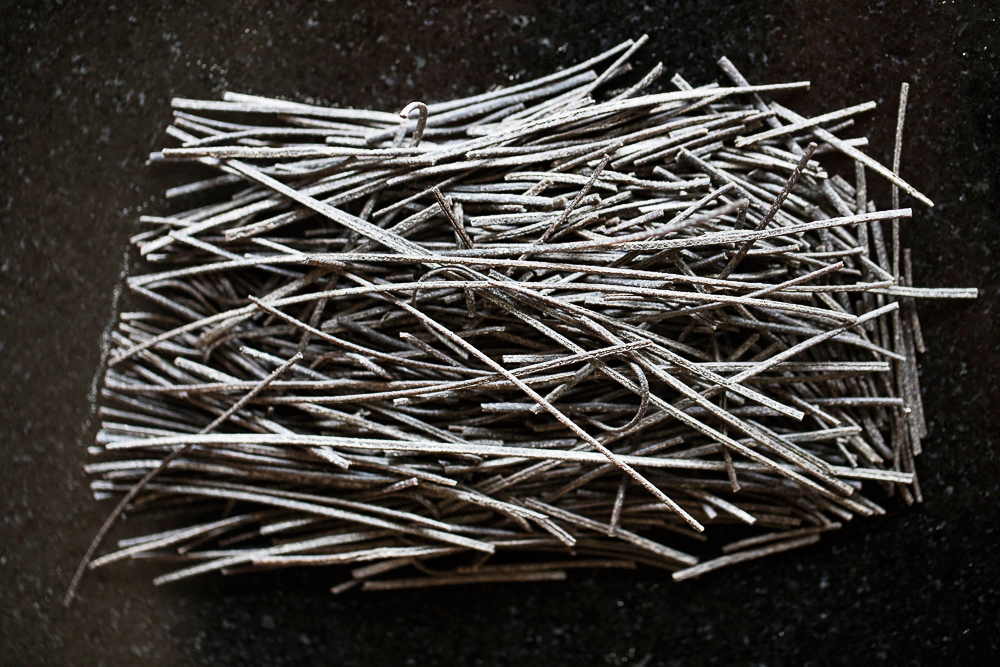black on black food photography of a stack of black bean pasta.